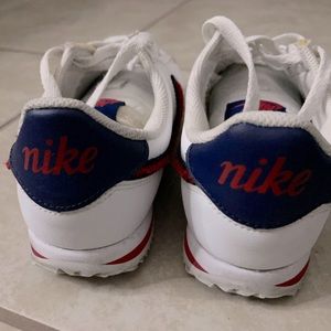 Red and White Nike Cortez with fuzzy swoosh